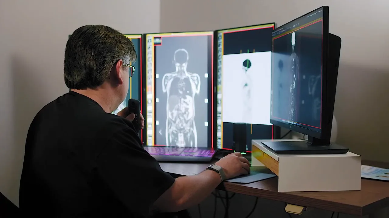 Dr. Daryl Eber reviewing whole-body MRI studies across multiple monitors